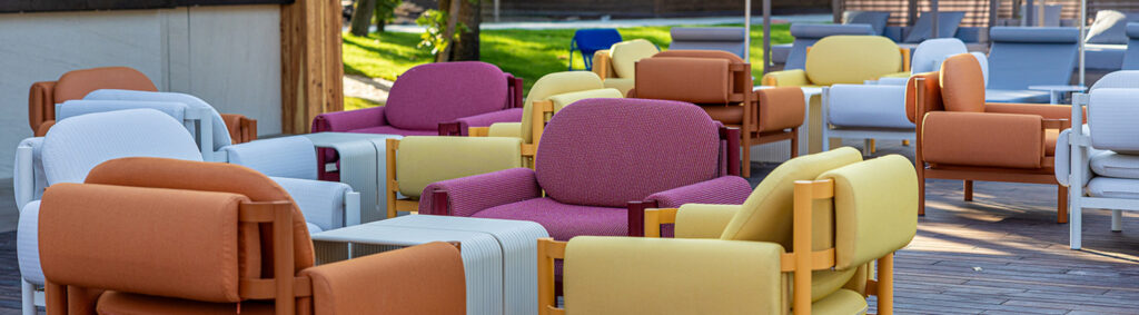A wooden deck featuring a cluster of colorful chairs and tables perfect for enjoying the outdoors 1