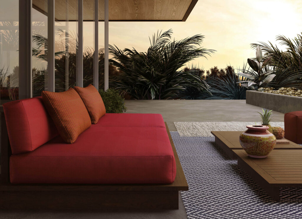 a dreamy evening patio with a red couch upholstered in fibreguard outdoor fabrics